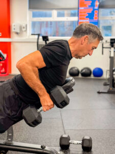 Man in his 60s confidently lifts weights